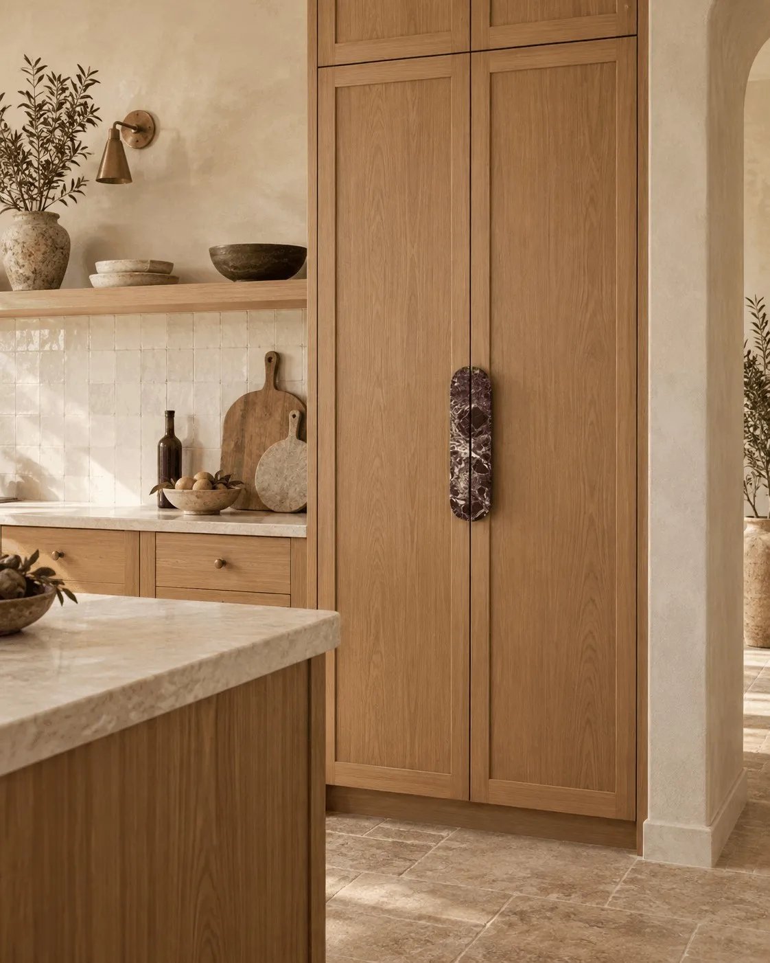 An Oval Pull in red Rosso Levanto marble on an oak pantry door, beside a limestone counter